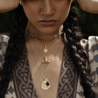 Close-up of a person wearing gold Loft & Daughter boho necklaces with intricate designs.