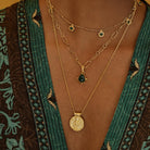 Close-up of model wearing Forever Young Pendant, capturing soft light on engraved Apsara design