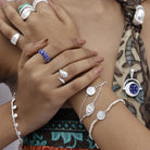 Close up of model wearing delicate silver stacking bracelets by Loft & Daughter for courage and abundance.