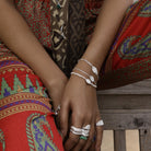Model wearing dainty boho stacking bracelets by Loft & Daughter featuring Lakshmi and Durga goddess coins worn with silver stacking rings