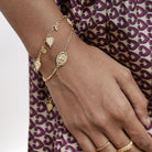 Model wearing Baby Courage oval coin stacking bracelet with mini coin bracelet.