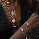 Model wearing delicate silver evil eye stacking bracelet symbolising protection and intuition, handcrafted by Loft & Daughter. Layered with other silver jewellery.