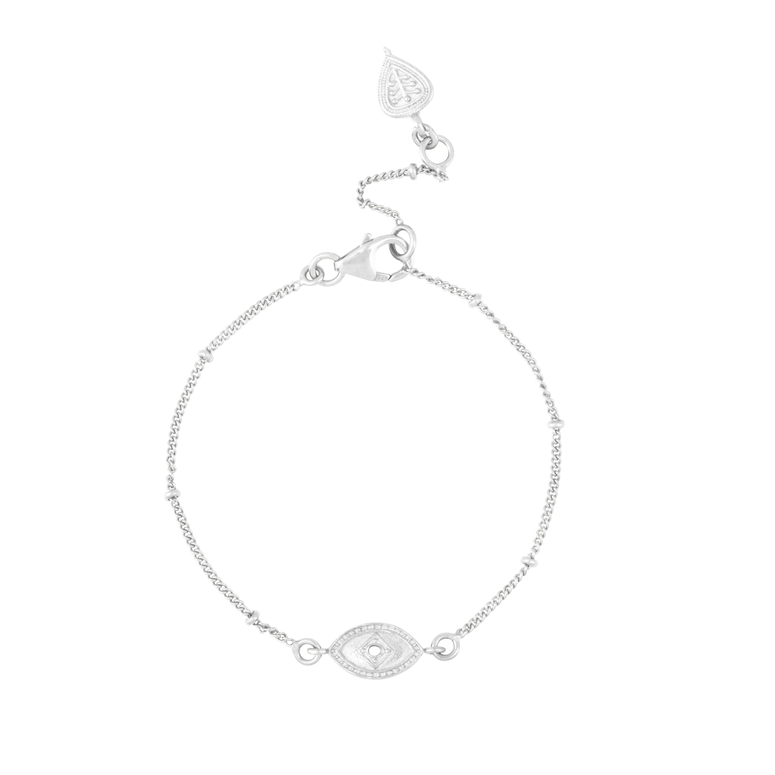 Silver bracelet with evil eye charm on a white background.