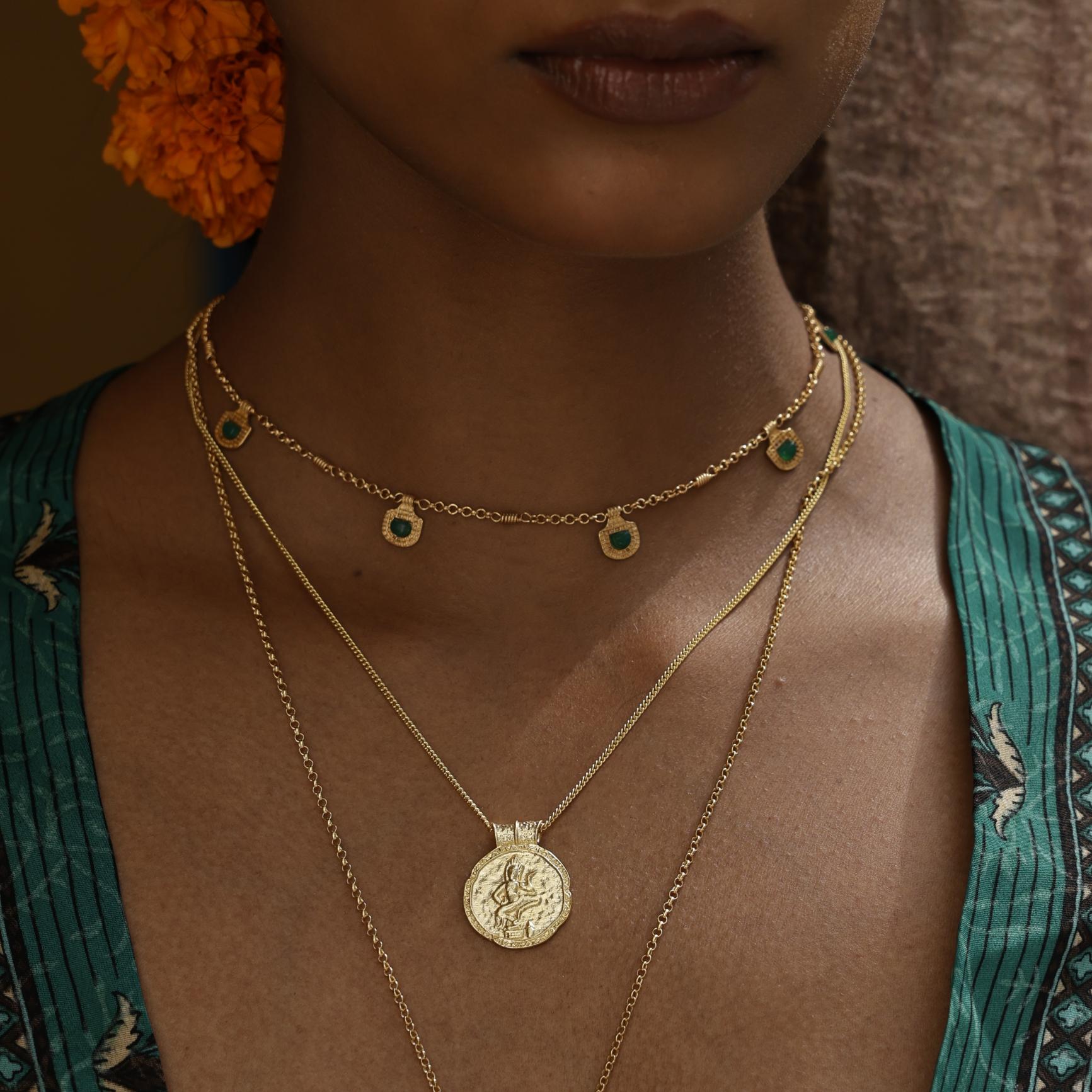 Woman wearing gold necklaces with a green kimono by Loft & Daughter