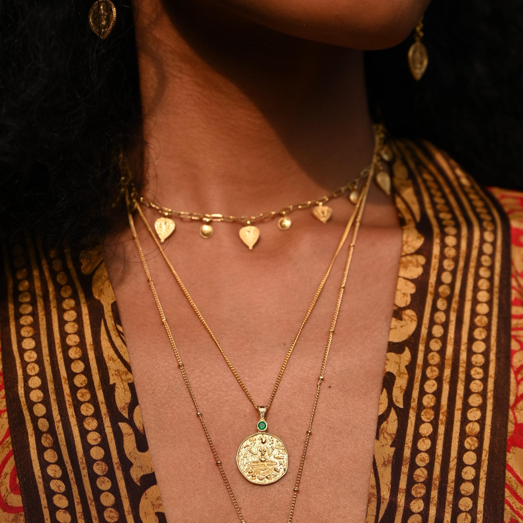 Close up of model wearing Lakshmi coin pendant