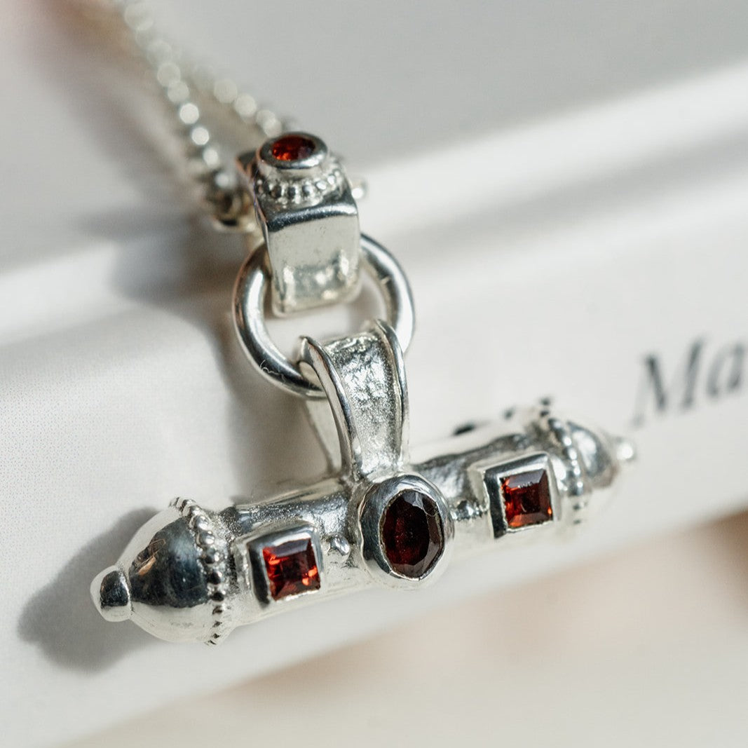 Silver talisman necklace with gemstones on a light background