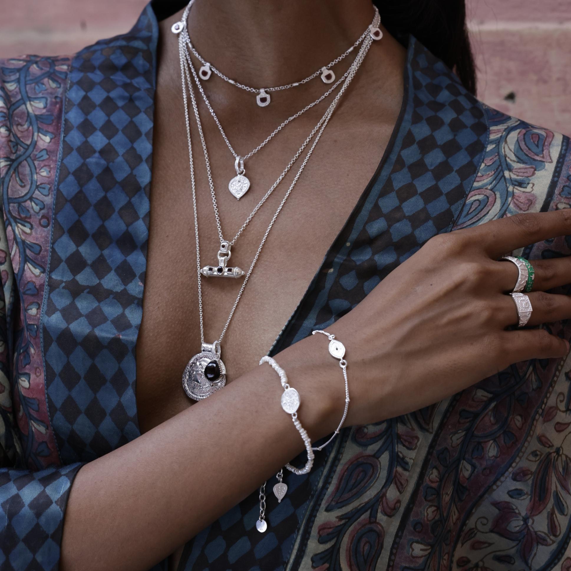 Model wearing goddess layering pendants with red garnet talismans by Loft and Daughter