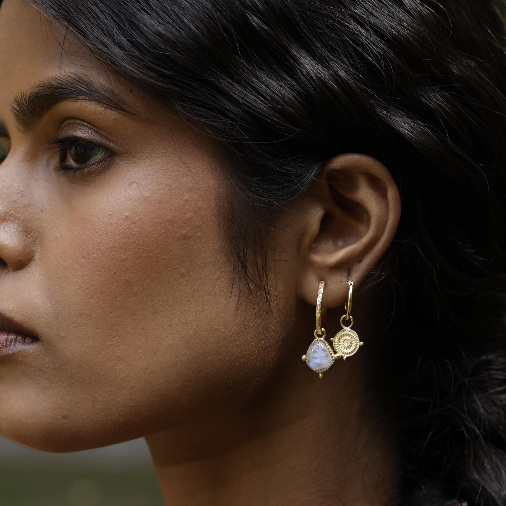Close up of model wearing moonstone drop hoop earrings with small coin stacking earring