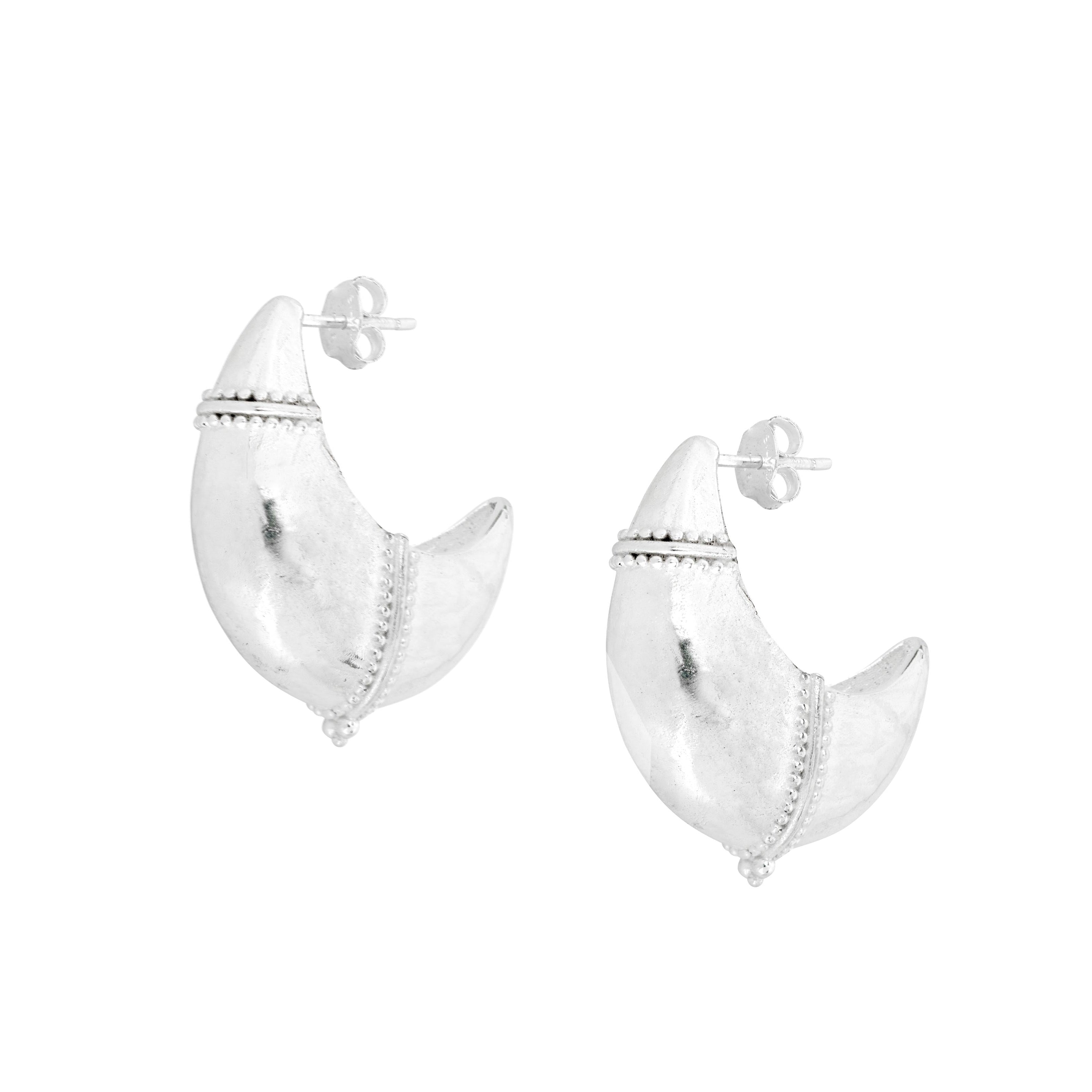 Large domed crescent earrings with tribal finish on white background
