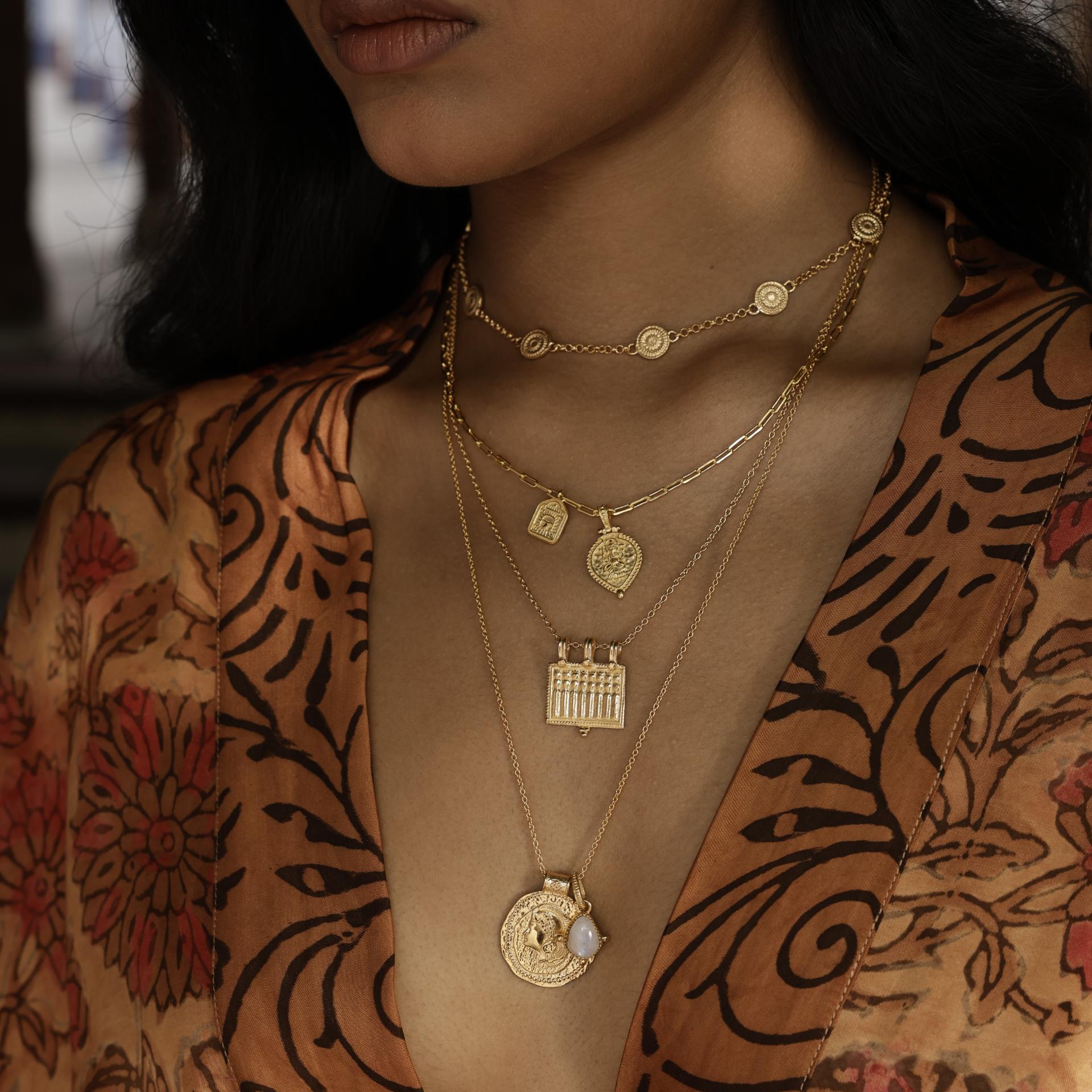 Model wearing Long Athena You Got This gold vermeil pendant layered with other meaningful talismans