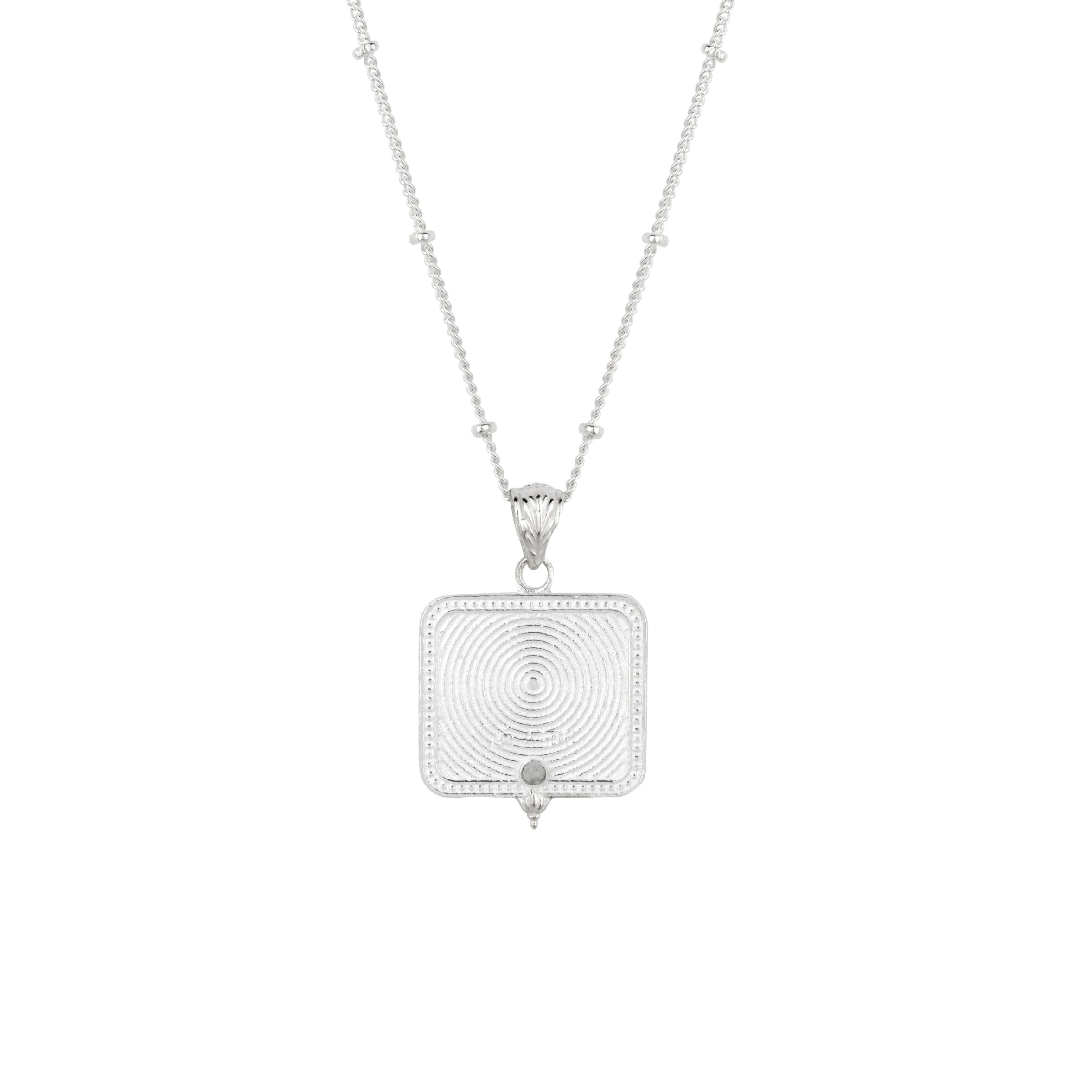 Reverse of silver Saraswati pendant showing spiral engraving and pearl detail