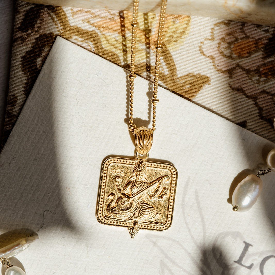 Gold Saraswati pendant necklace on a Loft & Daughter jewellery card with pearl beads