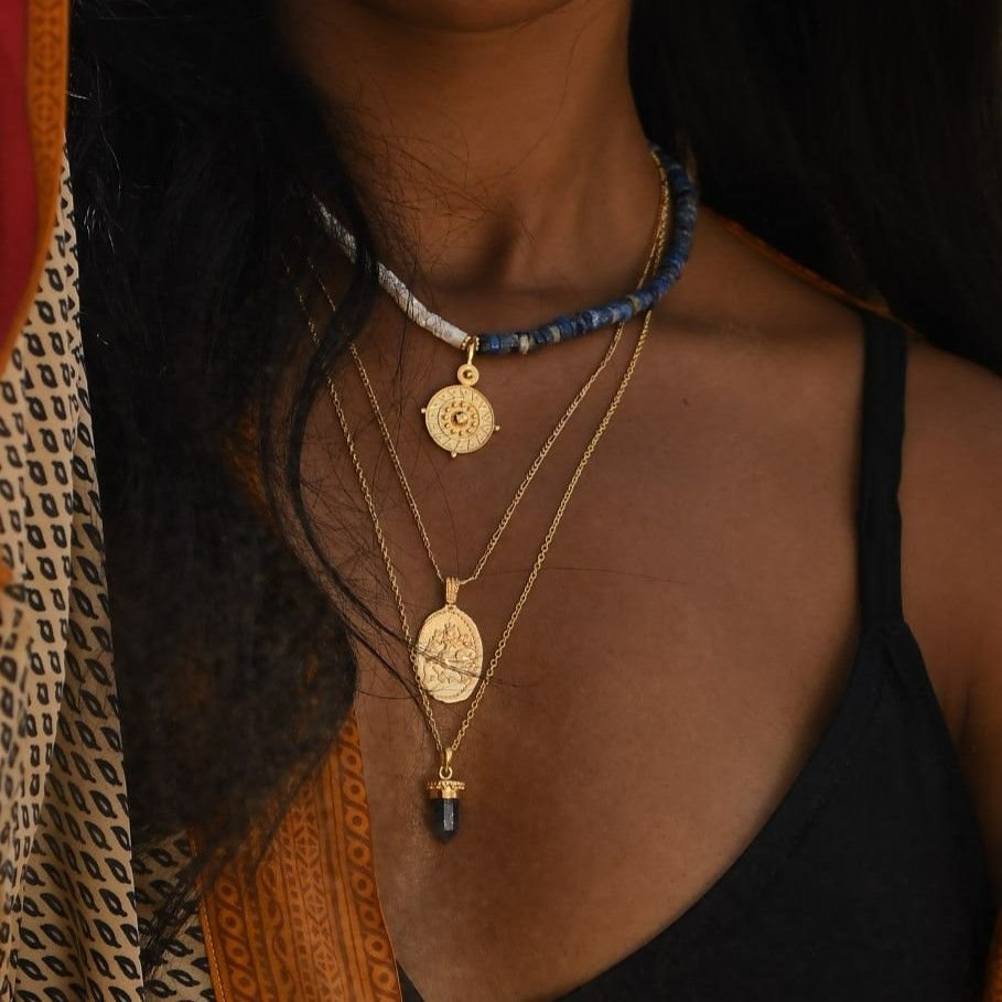 Gold vermeil goddess Durga pendant layered with symbolic pendants. Ethically handcrafted by Loft & Daughter.