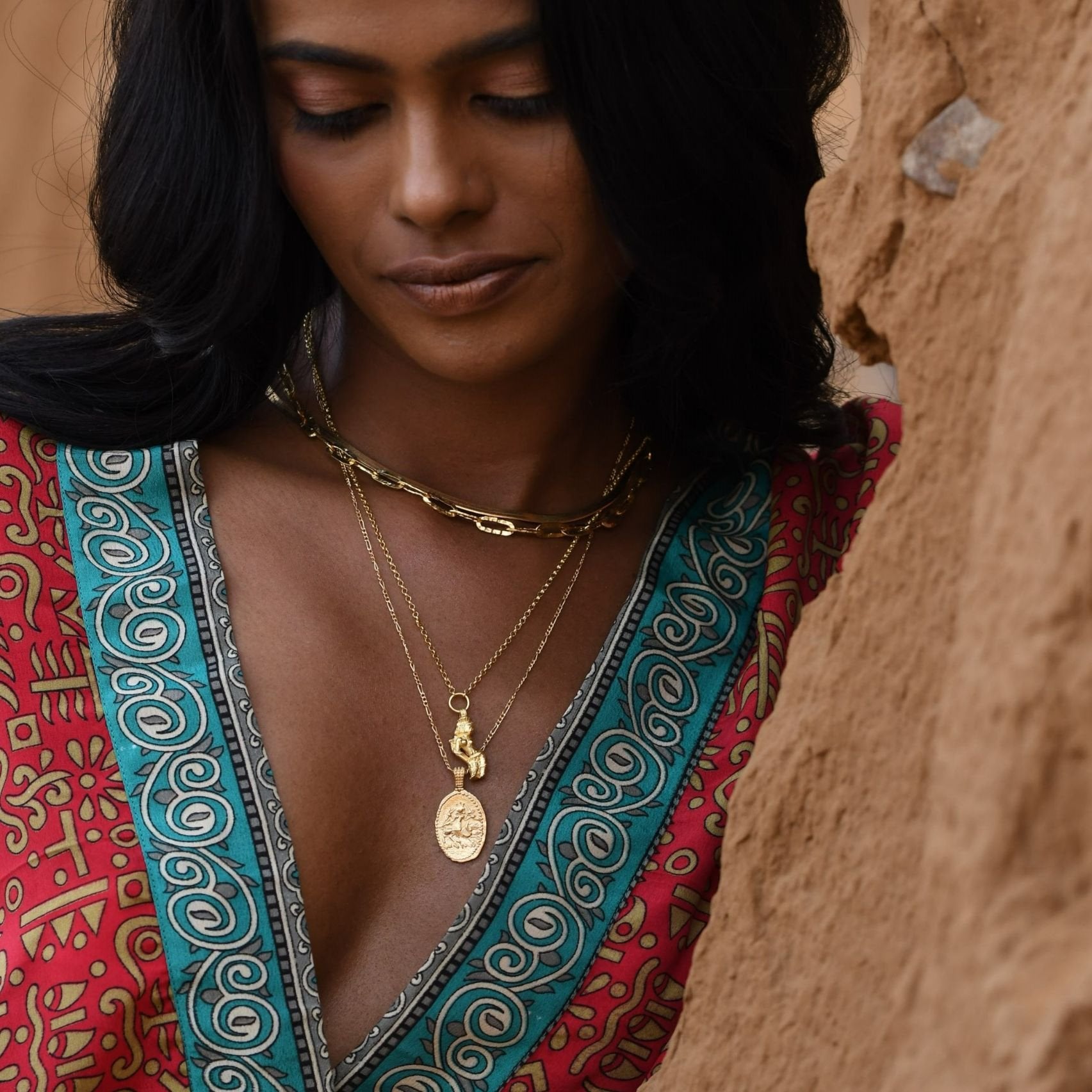 Model wearing stacked gold pendants featuring the Hindu goddess Durga by Loft & Daughter