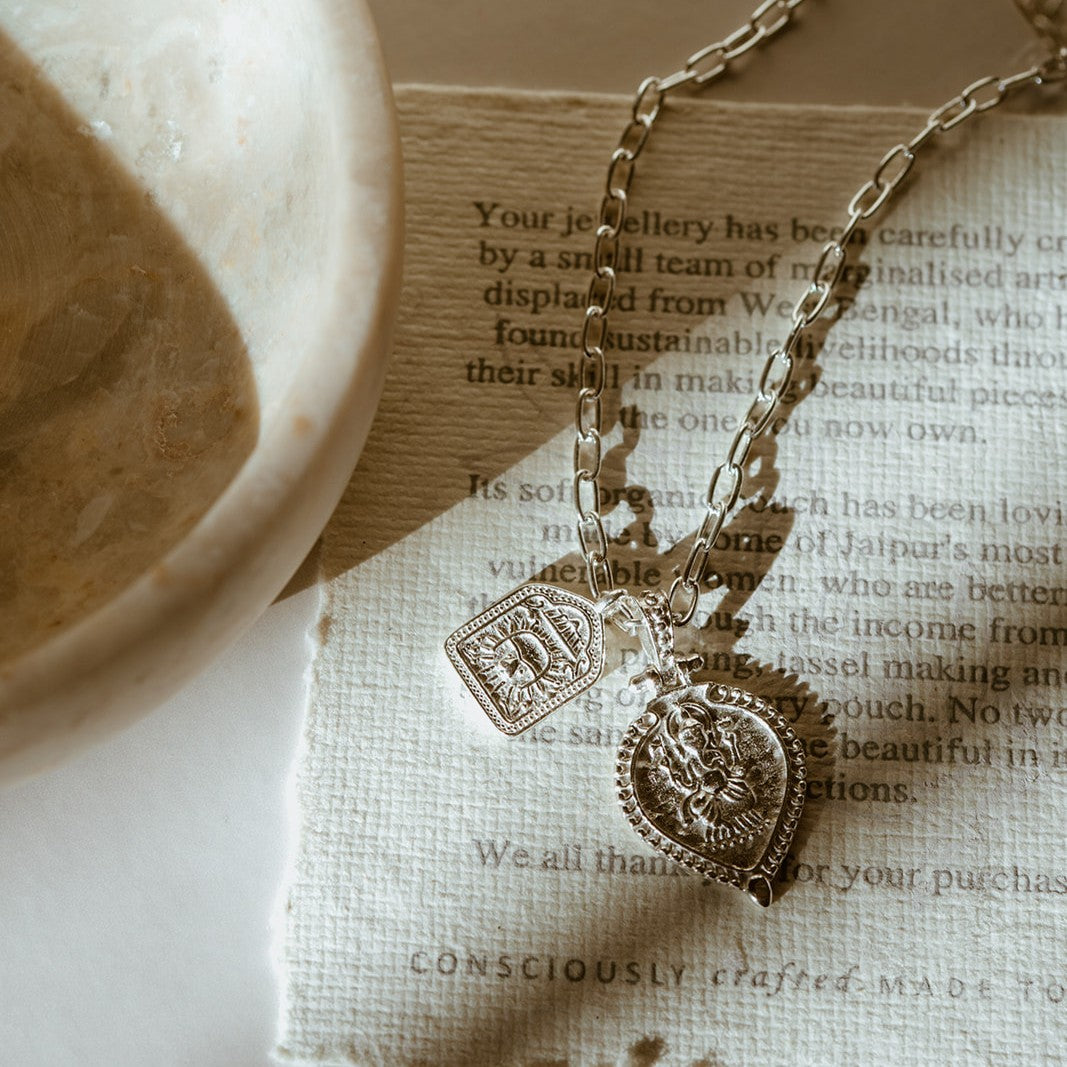 Silver Ganesh Magic Of New Beginnings pendant on textured paper