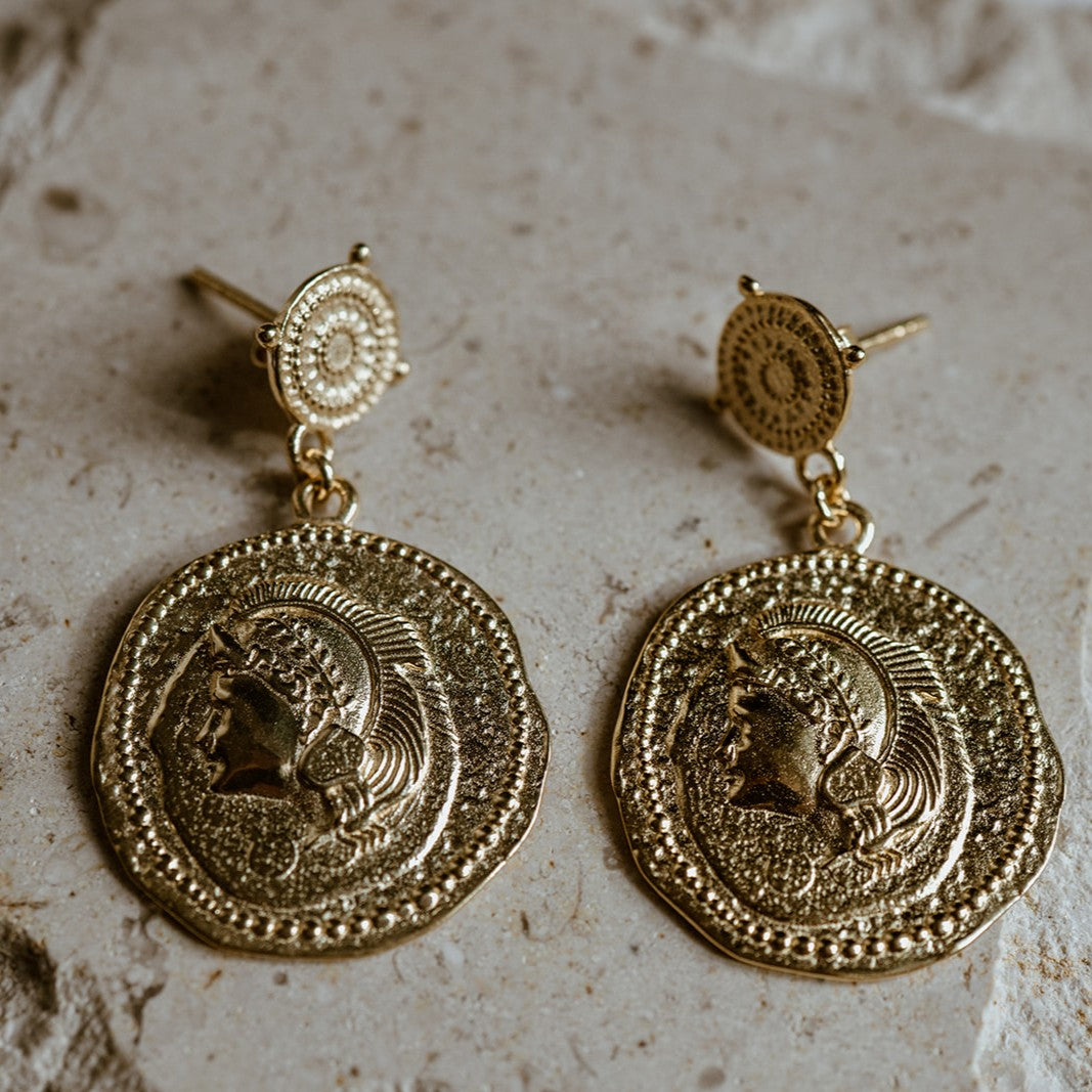 Statement silver Athena earrings inspired by ancient coins, symbolising strength and grace