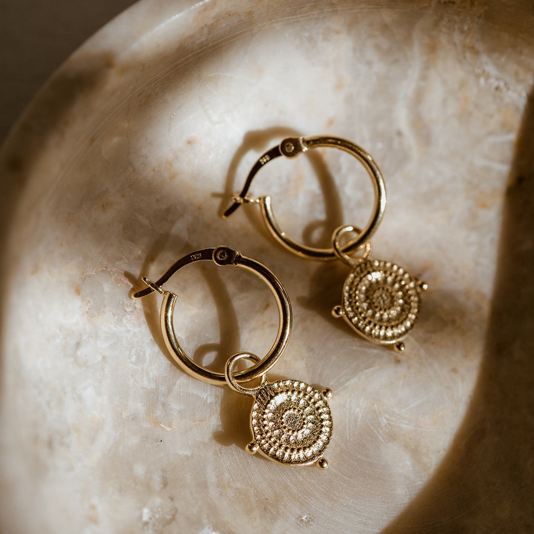 Close-up of Athena Shield Hoop Earrings in gold vermeil inspired by the goddess’s protective shield