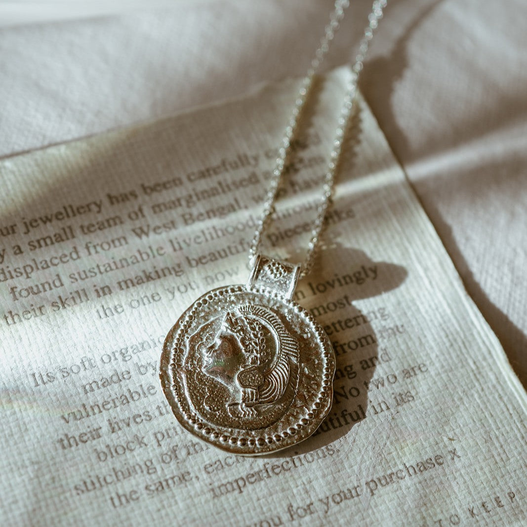 Close-up of Long Athena You Got This silver pendant featuring embossed goddess design