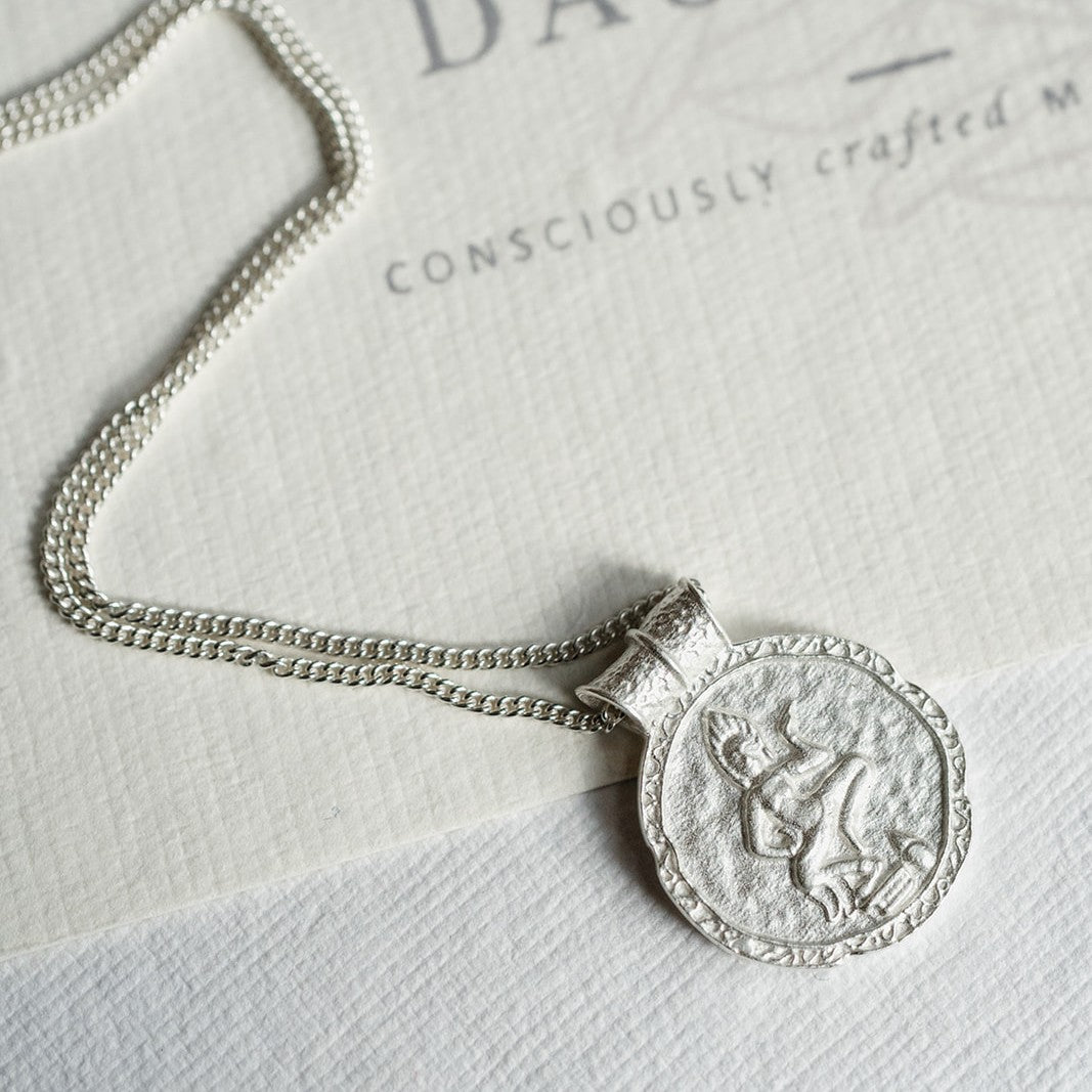 Close-up of gold Forever Young Pendant showing engraved back and fluid, sculptural curves inspired by the Apsara’s dance
