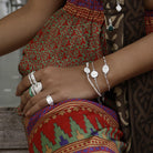 Close up of wrist wearing small silver Lakshmi, Durga and pearl stacking bracelets by Loft & Daughter