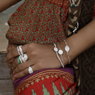 Dainty silver stacking bracelets by Loft & Daughter worn on model with multiple stacking rings with patterned trousers
