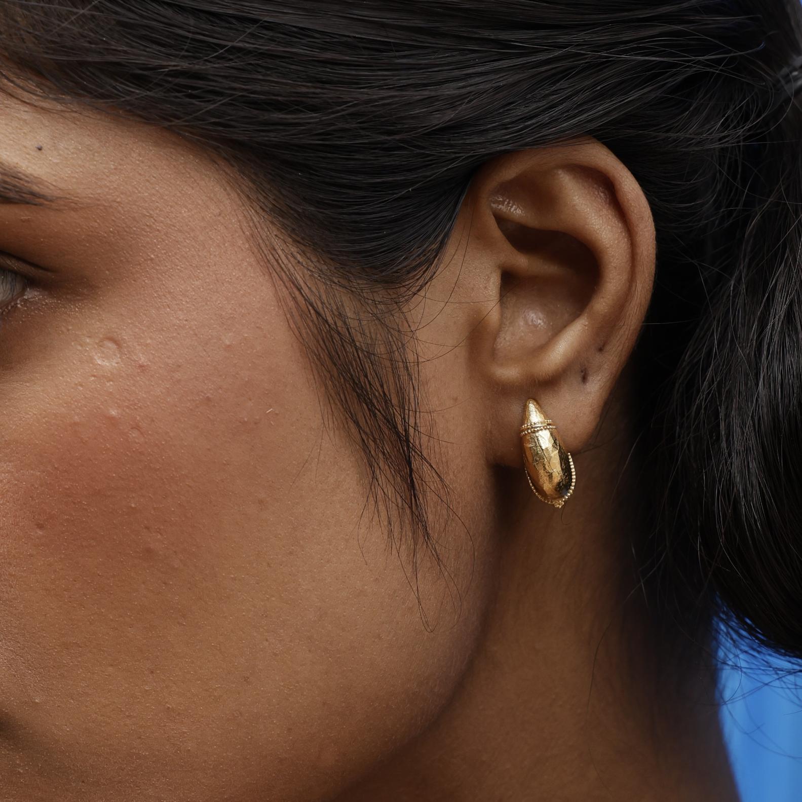 Model wearing Baby Valora Dome Hoops in gold, styled as subtle everyday earrings