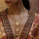 Model wearing the Nivara Amulet garnet necklace layered with other Loft & Daughter jewellery