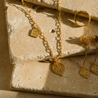 Close up of New Beginnings pendant with matching earrings on stone background