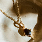 Gold and red garnet protective talisman pendant in sunlight