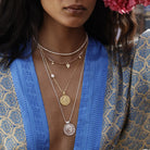 Woman wearing layered necklaces with a blue and patterned kimono