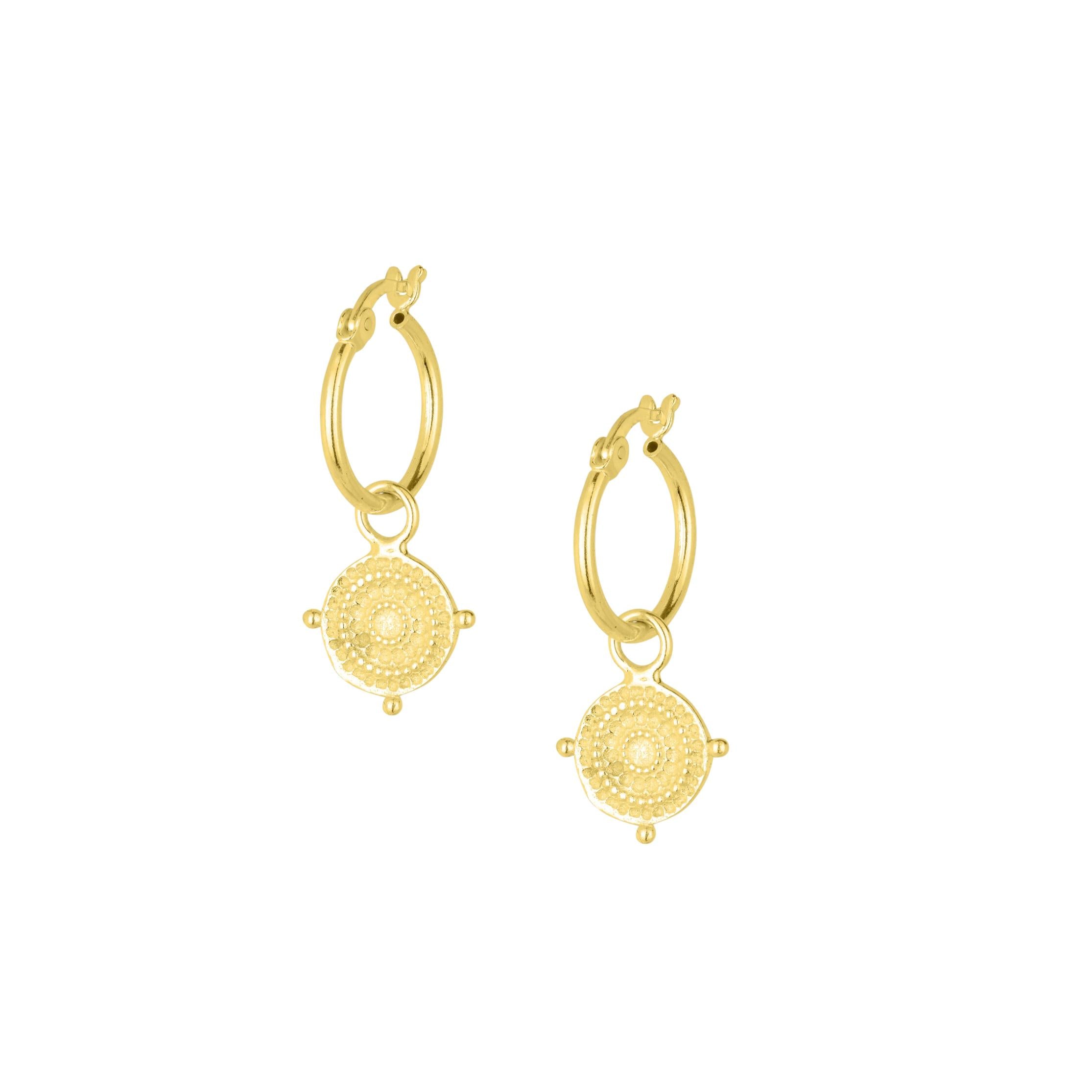 Gold hoop earrings in the style of Athena's sheild on a white background