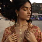 Boho stacking pendants on model with hair in the ari