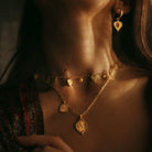 Close up of model wearing double charm Ganesh pendant and boho mini coin choker