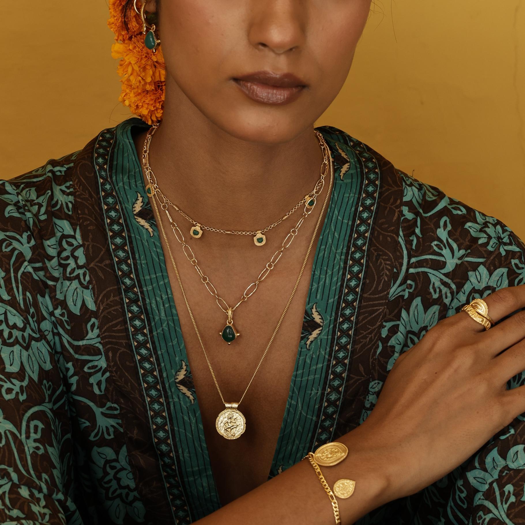 Model wearing boho layering necklaces with green gemstones and bohemian kimono