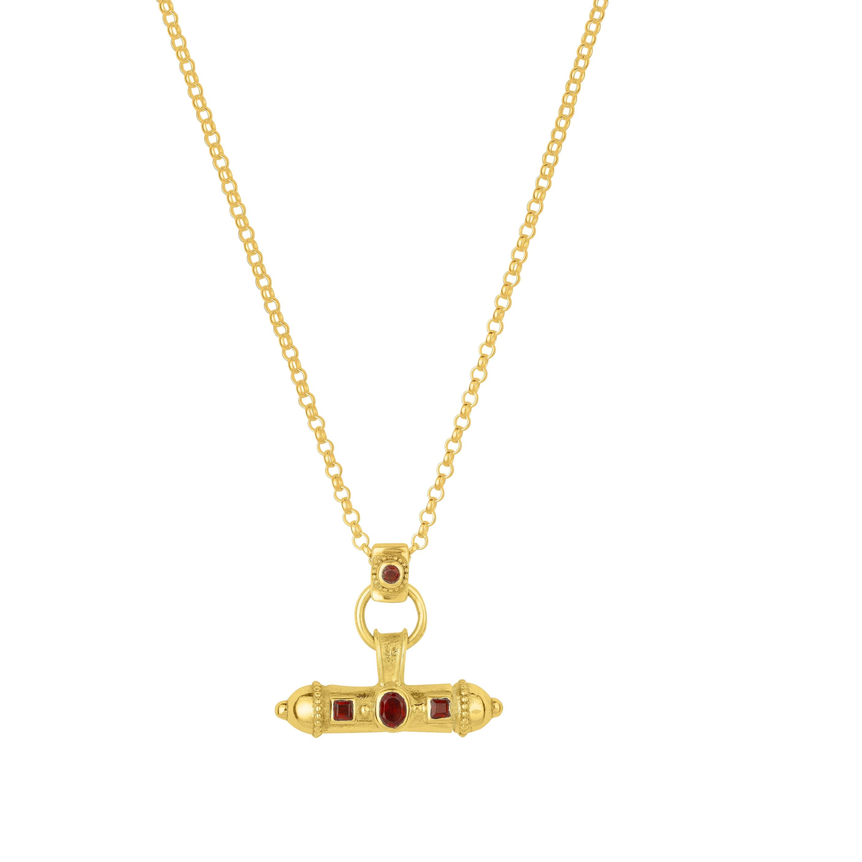 Close-up of the Nivara Amulet pendant with red garnet gemstones on chain