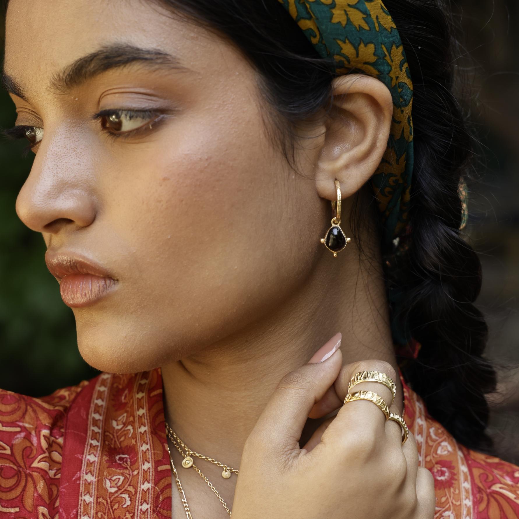 Red garnet healing stone hoop on model with stacking rings and red kimono