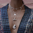 Model wearing the Nivara Amulet Pendant layered with other Loft & Daughter talismans