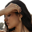 Model wearing chunky domed gold earrings