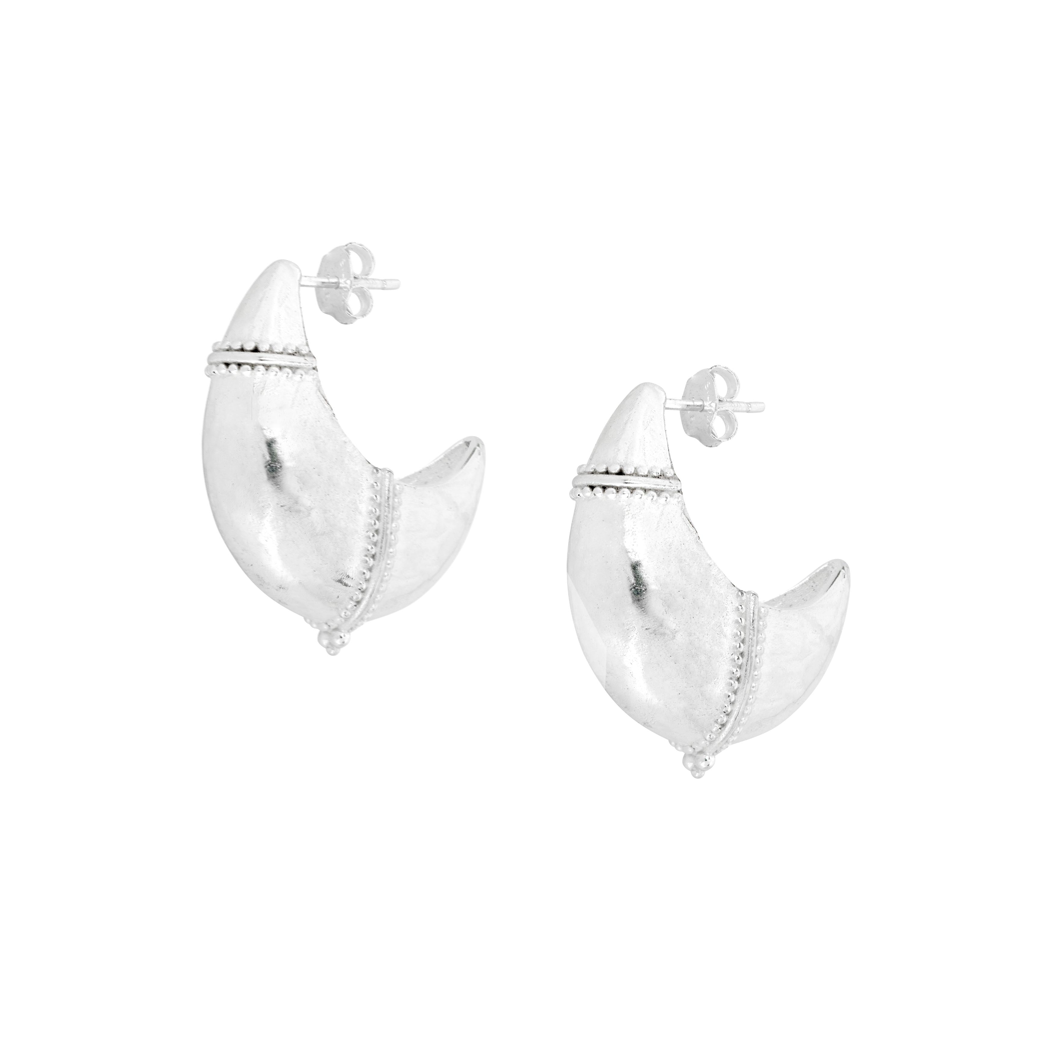 Large domed crescent earrings with tribal finish on white background