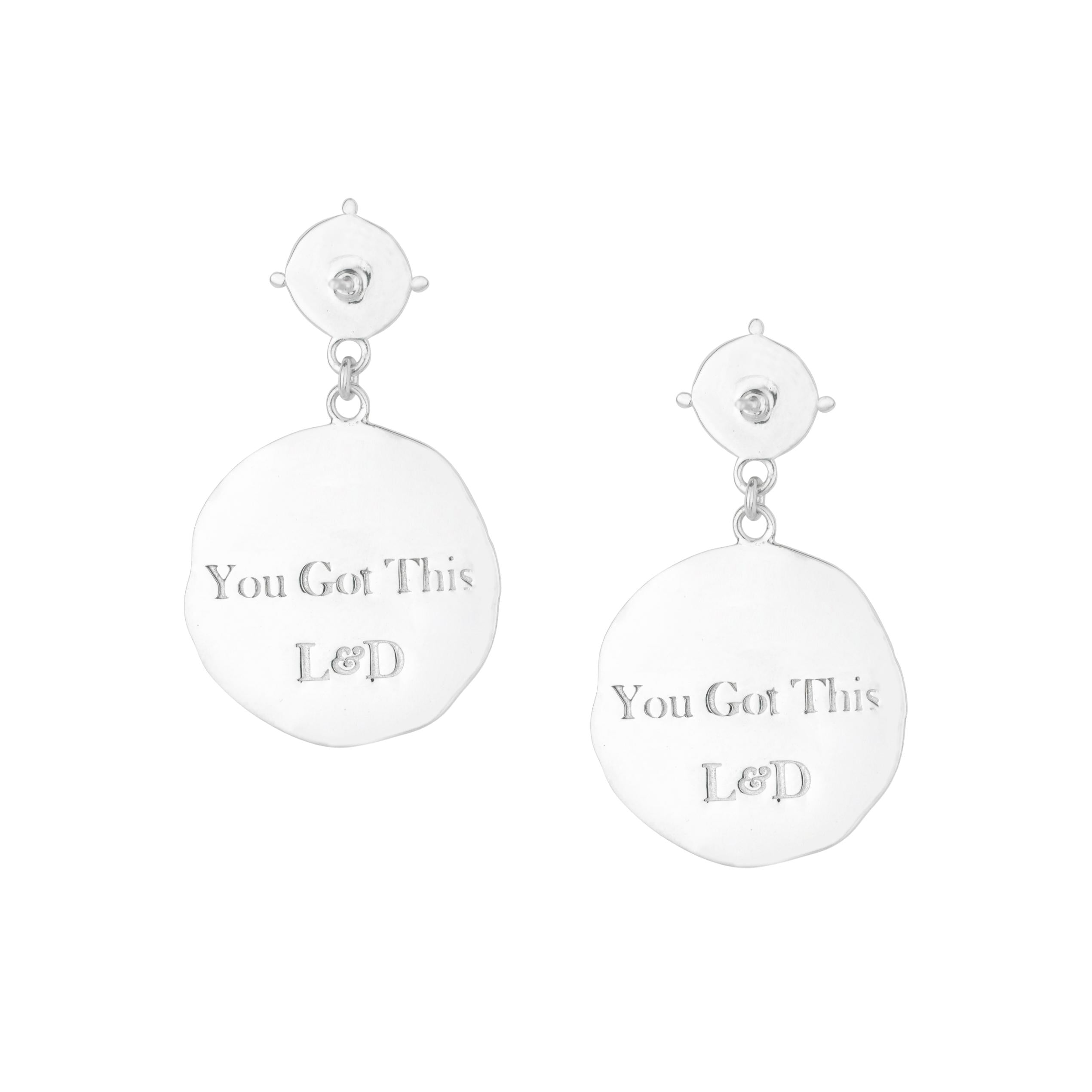 Silver earrings with 'You Got This L&D' text on a white background