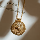 Close-up of Long Athena You Got This gold vermeil pendant featuring embossed goddess design