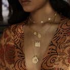 Model wearing Long Athena You Got This gold vermeil pendant layered with other meaningful talismans