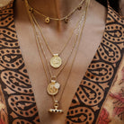 Model wearing the Nivara Amulet garnet necklace stacked with other Loft & Daughter gold coin pendants