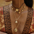 Athena gold pendant styled as a modern-day shield of inner strength worn with layering pendants
