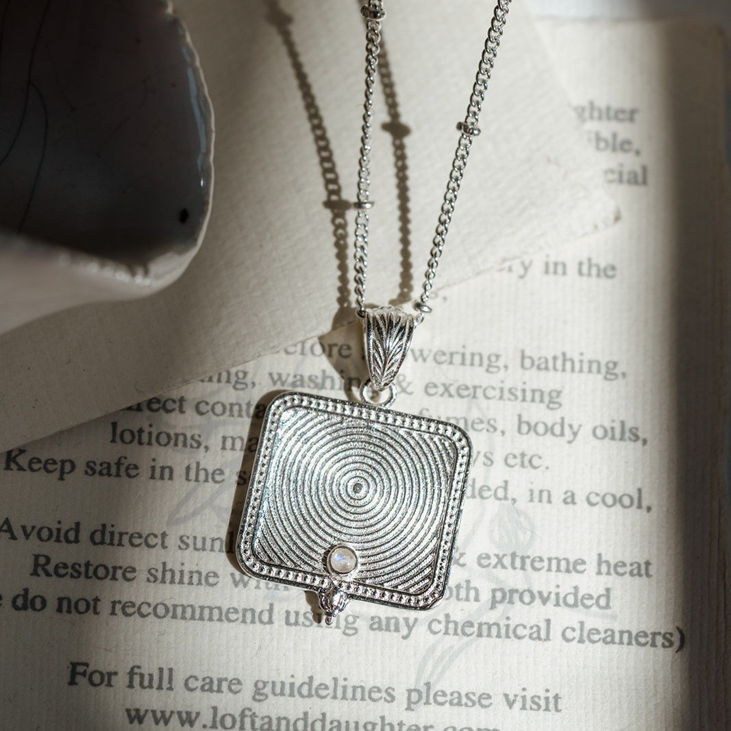 Silver spiral Goddess pendant necklace with pearl accent on a jewellery card
