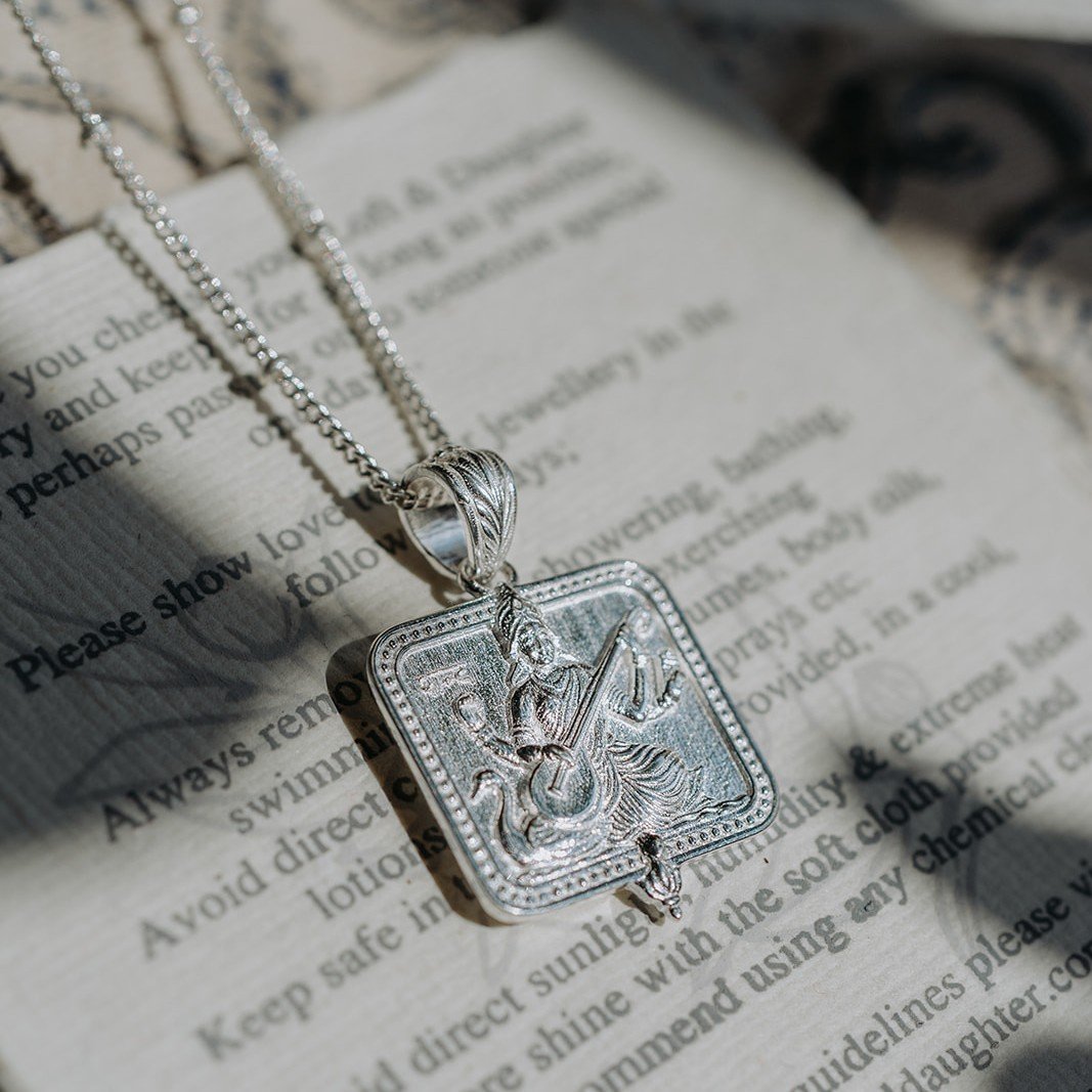 Close-up of silver Saraswati pendant necklace engraving detail