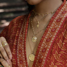 Athena-inspired shield necklace styled with bohemian layers and patterned kimono