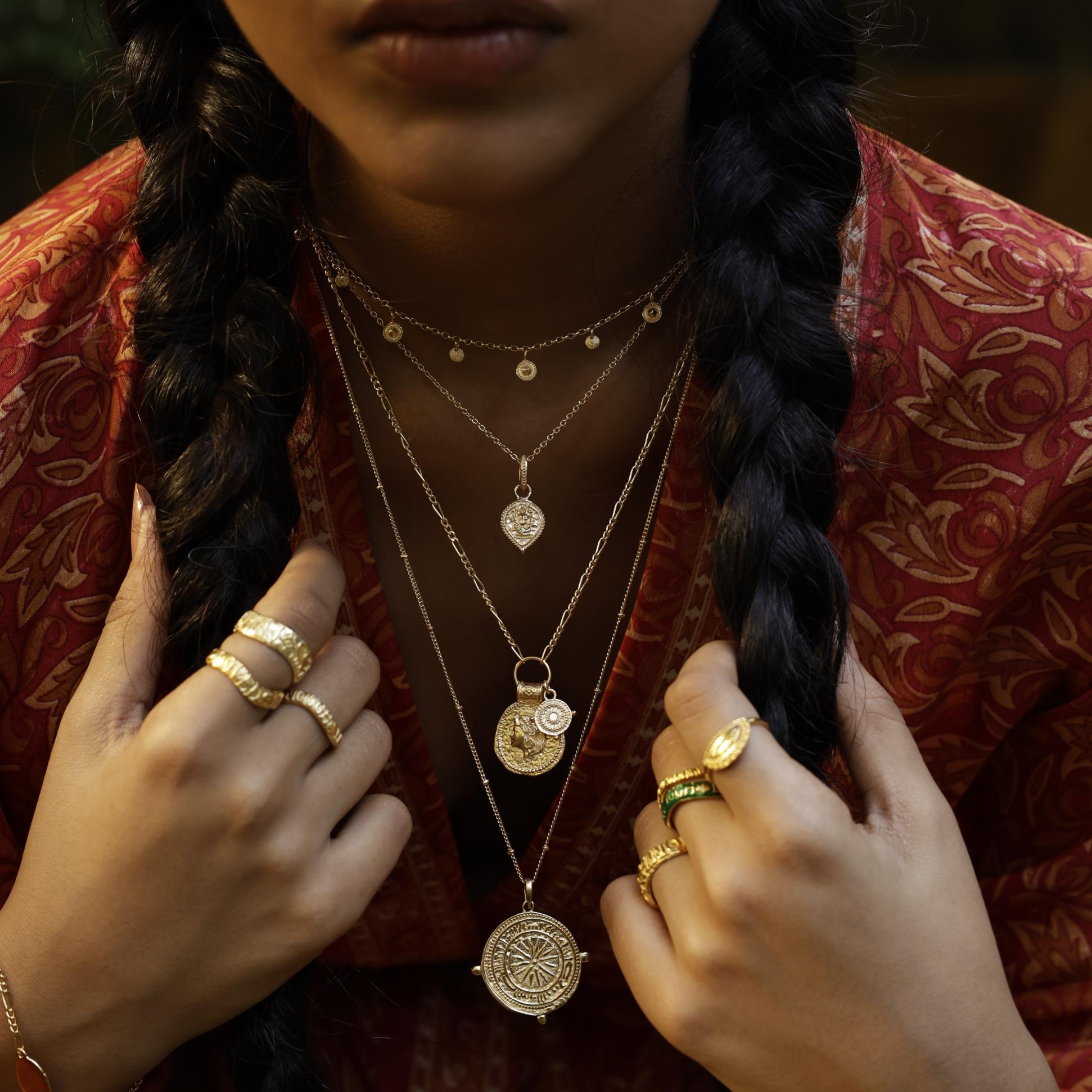 Woman wearing You Got This Shield Pendant as a symbol of inner strength. Layered with Loft & Daughter pendants for a bohemian look.