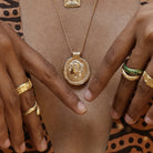 Model wearing Long Athena You Got This gold vermeil pendant with stacking rings