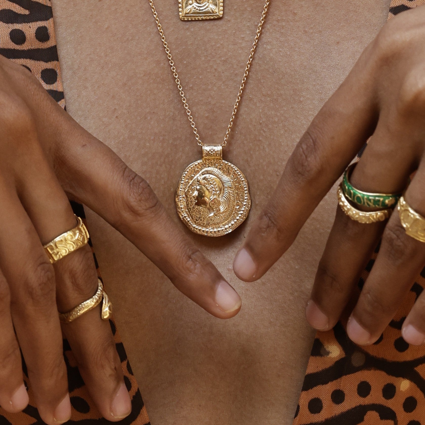 Model wearing Long Athena You Got This gold vermeil pendant with stacking rings